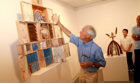 Ren Vidal montre au public son buffet avec les multiples tiroirs contenant des pages d'annuaires de Vidal du monde entier.